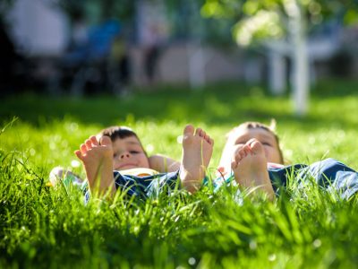 two boys lying down on the lawn